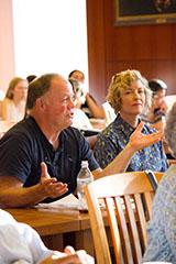 Man speaking during a classroom session with others attentively listening.