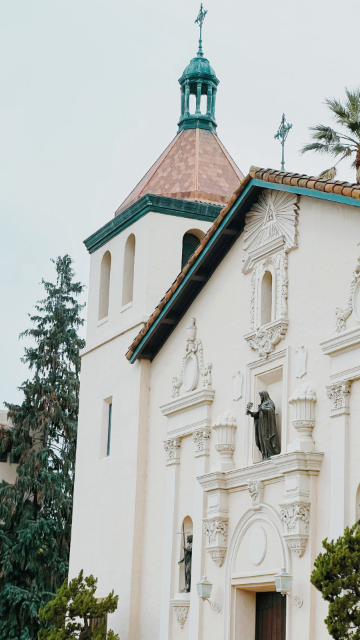 Historic mission-style church building with a cross on top.