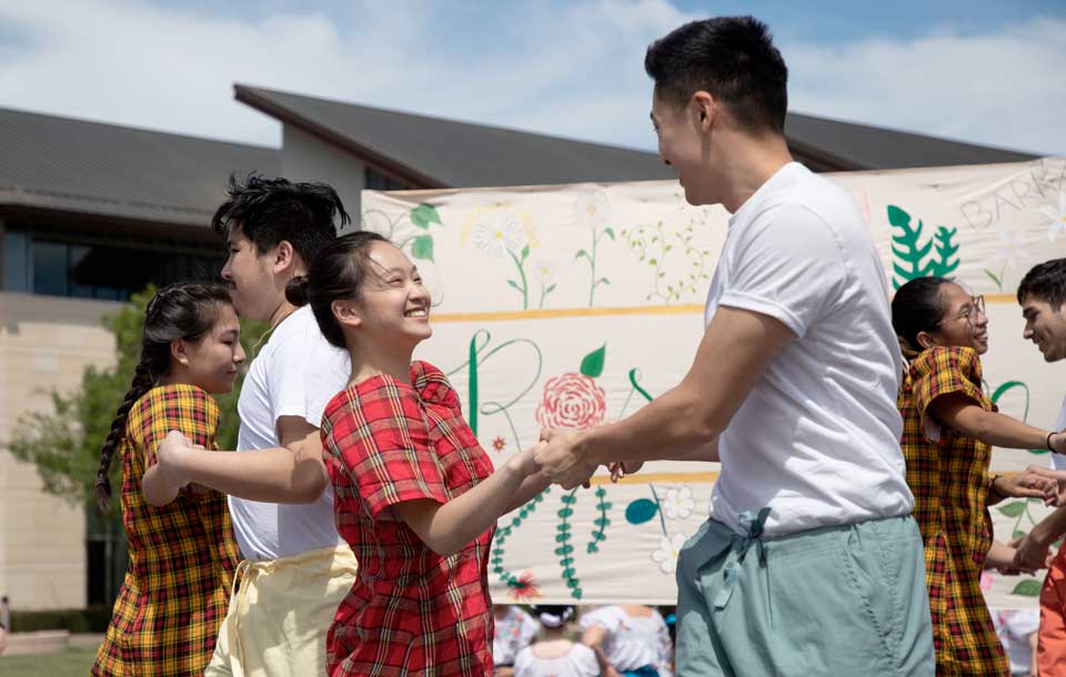 students cultural dancing in street fair 