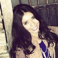 A woman smiling with a wooden door background.