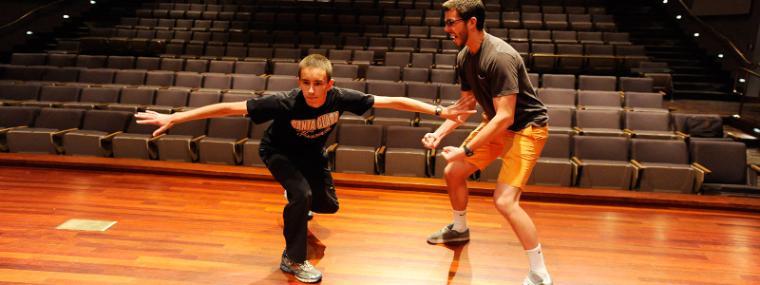Alt Text: Two people playing basketball on an indoor court. image link to story