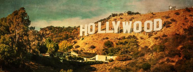 Alt text: Hollywood Sign on a hillside with trees and cityscape in the background. image link to story