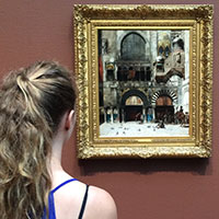 A person viewing a framed painting in a museum.