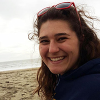 A person smiling on a beach.