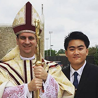 A religious leader and a man in a suit pose for a picture.