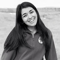 A smiling person in an outdoor setting.