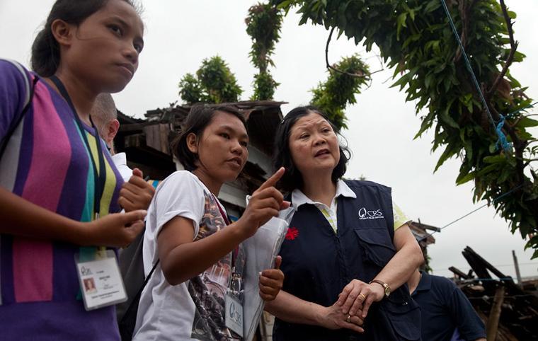 A woman in a navy outfit smiling with three people outside. image link to story