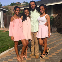 Four people posing outdoors on a patio, titled 'Rovaris'.