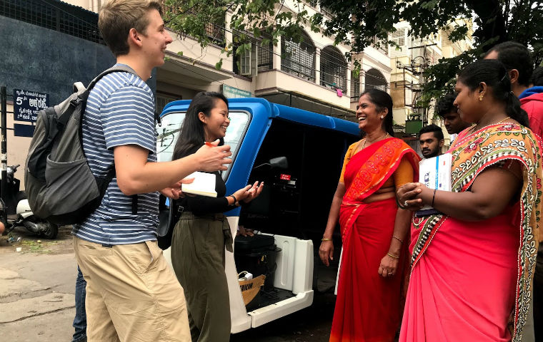 GSBF fellows smiling with women wearing red saris image link to story