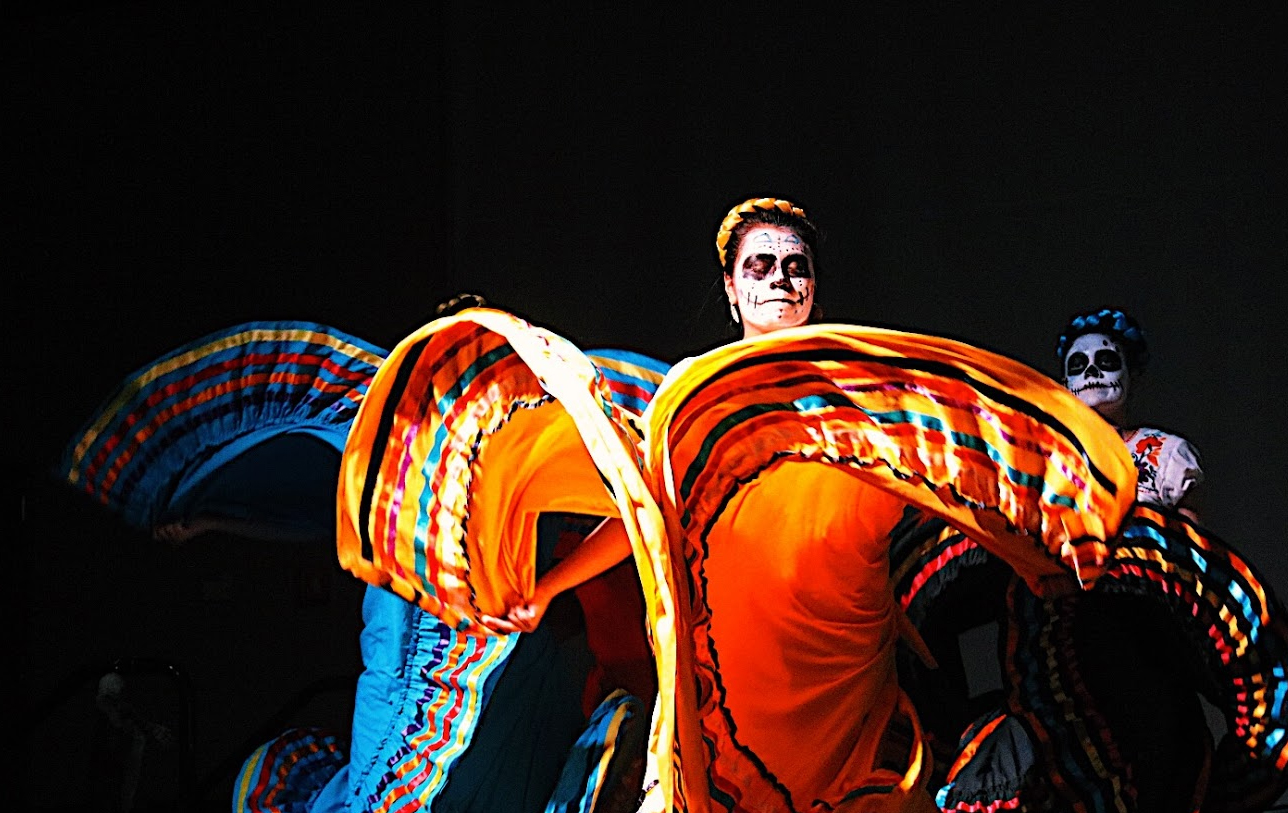 Ballet Folklorico members dance in colorful dresses and makeup