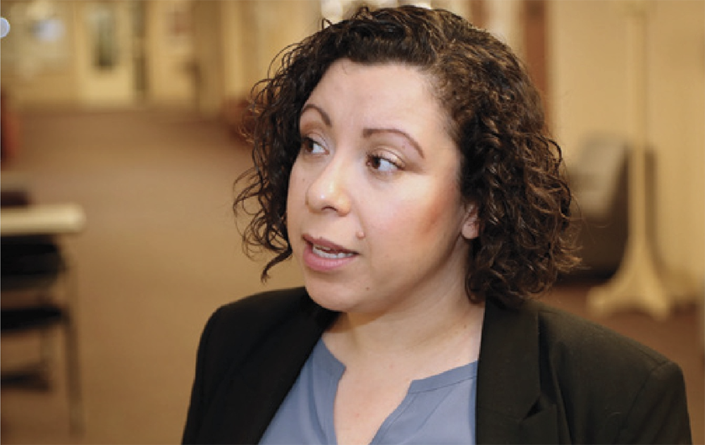 Claudia Rodriguez-Mojica talks in a hallway