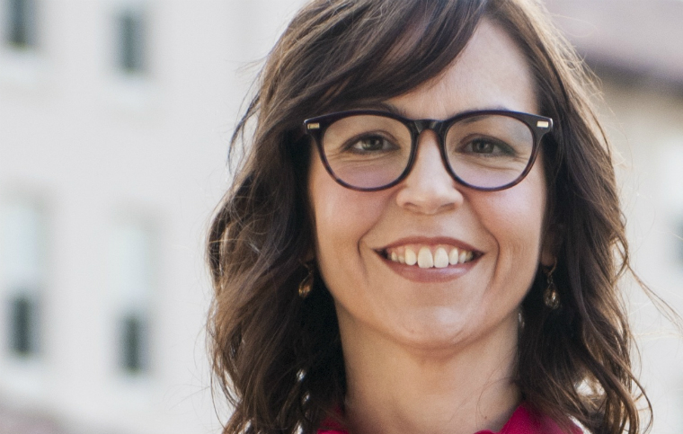 A person smiling, wearing glasses and standing outdoors. image link to story
