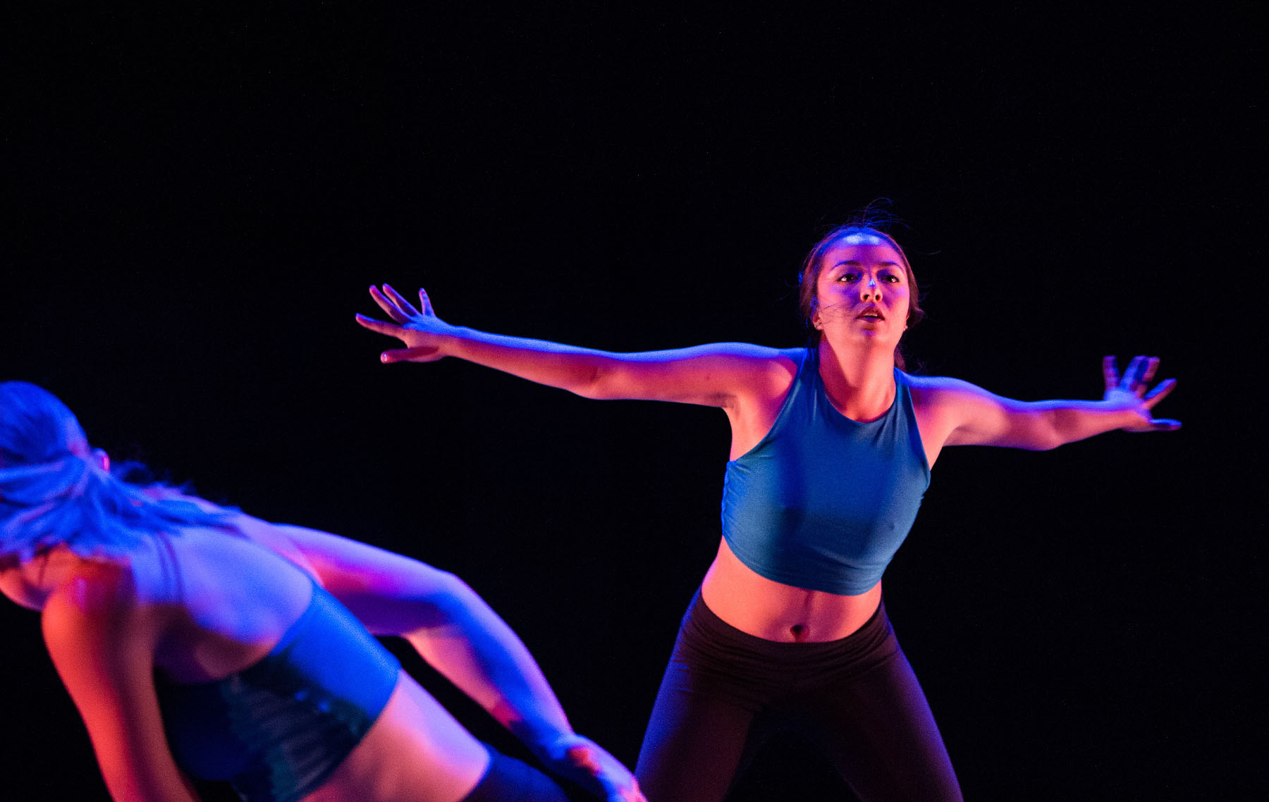 Young woman dances on stage.