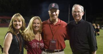 Photo of four people, Renee Baumgartner, Mary and Mark Stevens, Michael Engh, S.J., at an SCU sports game