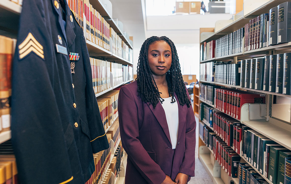 Ashanti Wallace stands beside her U.S. Army uniform inside the law library.