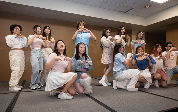 DayBreak dance members pose together as a team with their hands making a heart shape.