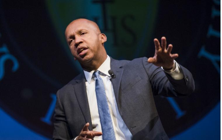 Bryan Stevenson speaking at an event, wearing a suit and tie. image link to story