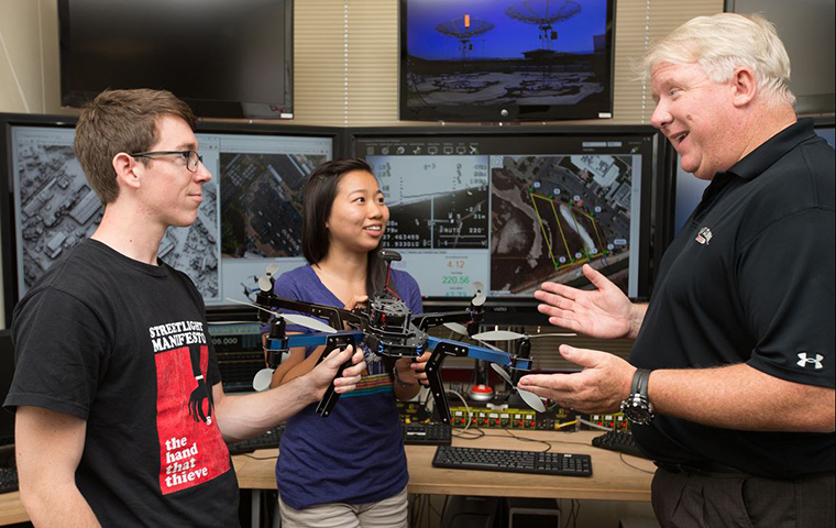 Chris Kitts working with two students in the Robotics Lab. image link to story