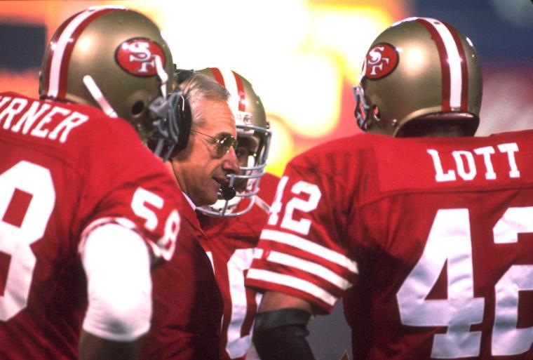 A football coach and players in a huddle. image link to story