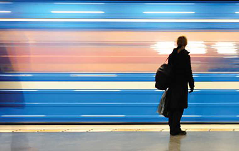 Woman staring at streaking lines of subway