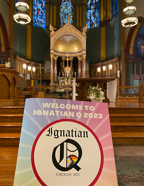 A brochure for the Ignatian Q conference held with the interior of a Catholic church in the background.