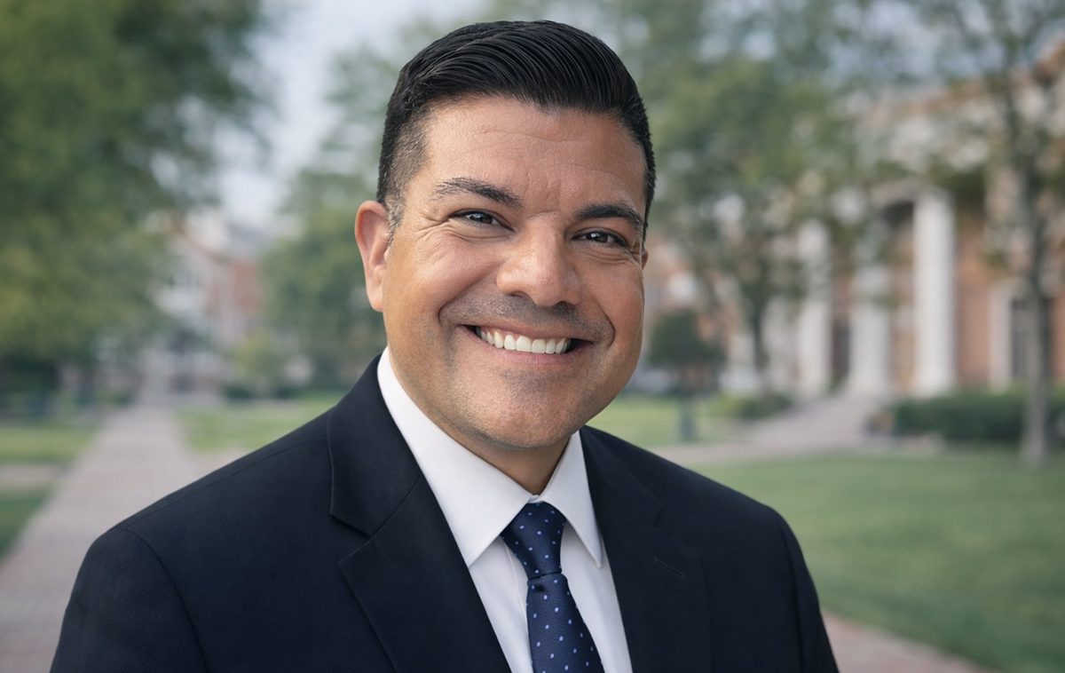 Jose Cabrales in black suit standing in front of grassy area