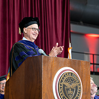 Dean Michael Kaufman applauding the Law Class of 2024 at podium