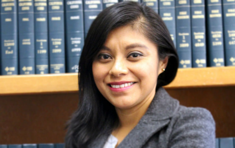 Lizbeth Mateo standing in front of law books