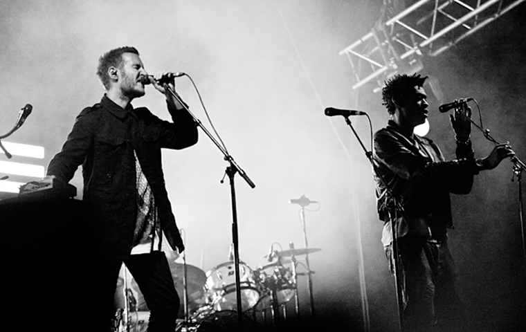 Two musical performers sing on stage.