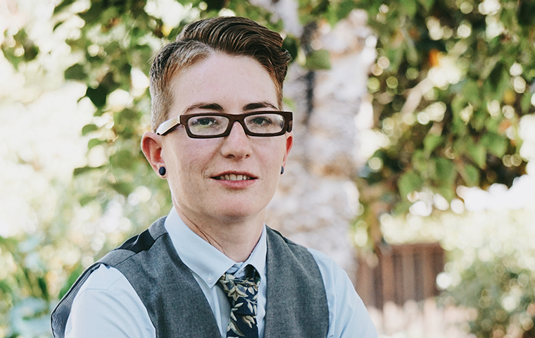 A person in glasses and a vest looking at the camera.