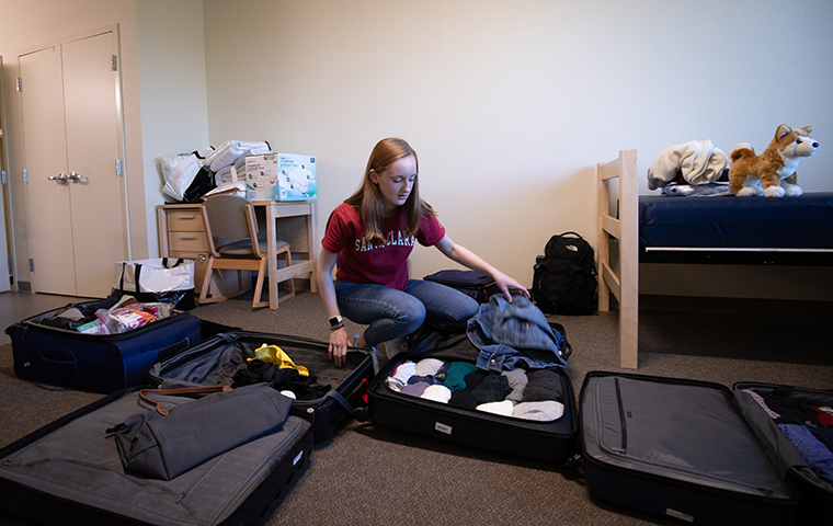 Student unpacking backpacks on floor