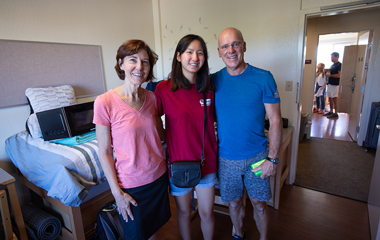 Parents with daughter in residence hall room. 