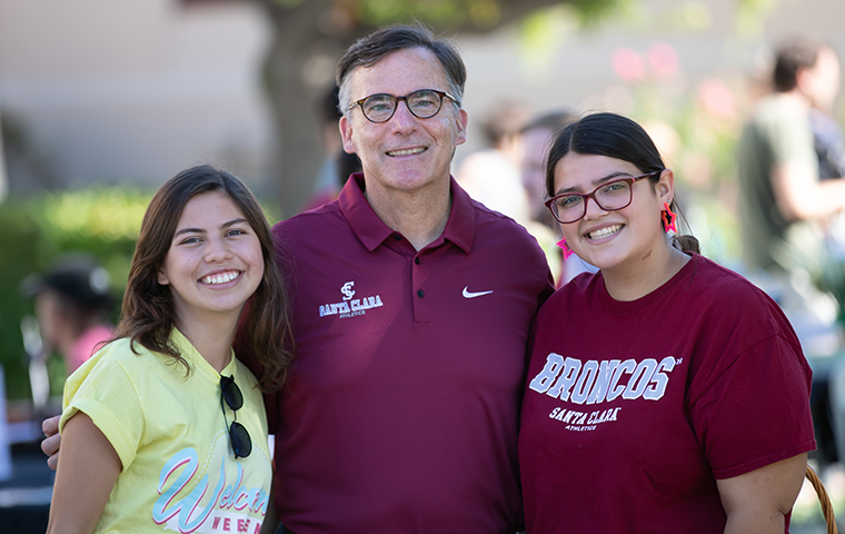Father Kevin O'Brien with two students at move-in