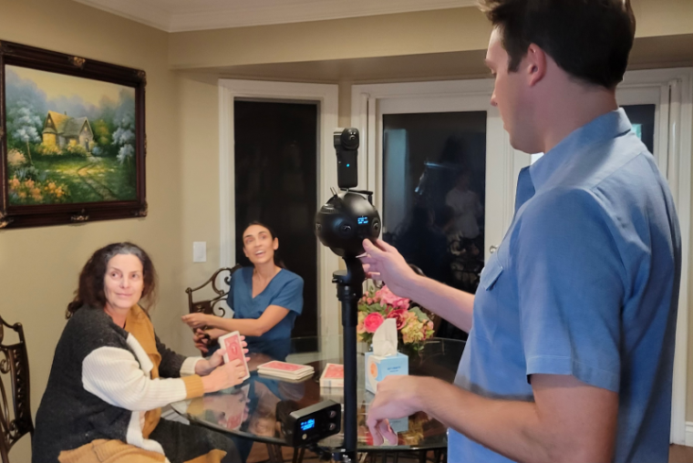 A student filming a VR video featuring two women as Alzheimers patient and caregiver