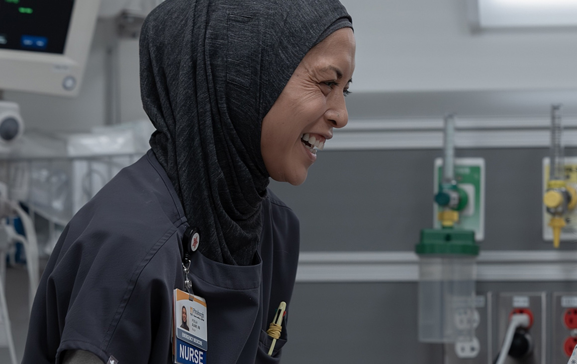 Amielynn Abellera in character on the HBO show The Pitt as Nurse Perlah, a woman in a hijab and nurse scrubs.
