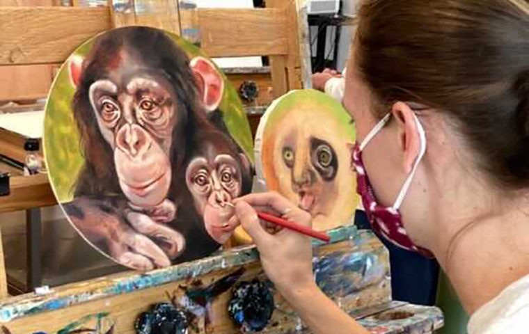 Student artist paints two monkeys