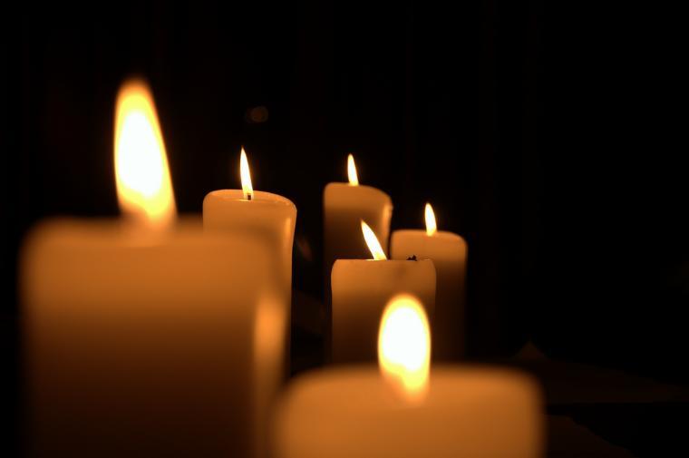 Lit candles in the dark, creating a warm glow. image link to story
