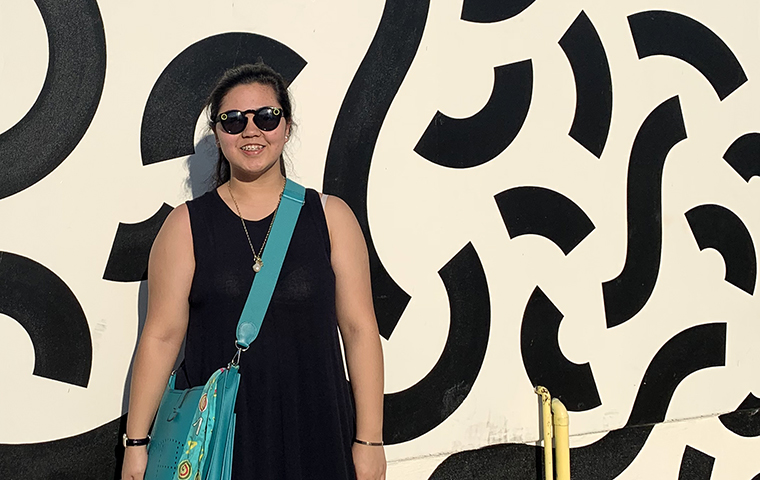 Danielle Yabut stands in front of street art