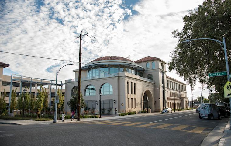 Street view of Dowd building with cloudy sky and trees. image link to story