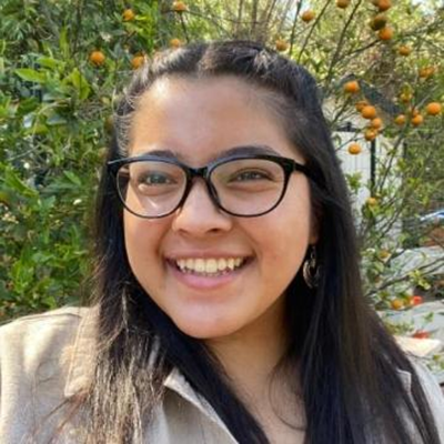 Giselle Aviles Giselle Aviles standing in front of a green plant background