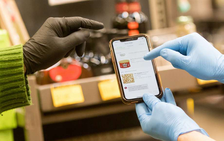 Two hands with medical gloves pointing to a phone screen. image link to story