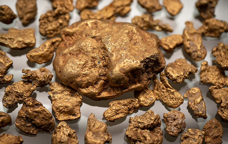 Gold nuggets sitting on a sheet of glass