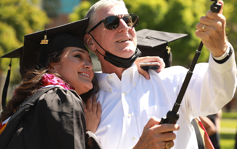 Graduating student getting a selfie with her dad