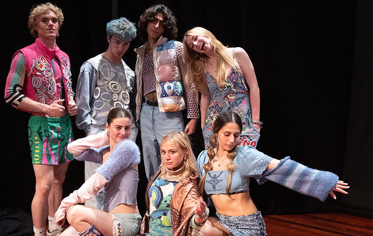 Photo of a group of students posing in upcycled designs they modeled at the EcoFashion Show.