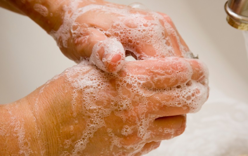 Image of two soapy hands at a sink. 