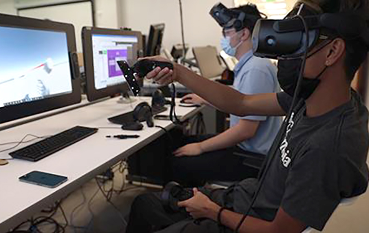 Students wearing VR equipment sitting in front of computers