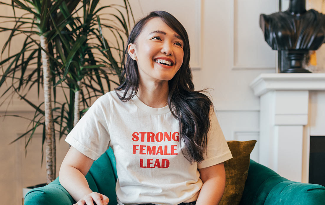 Judith Martinez, seated, wearing a shirt that says Strong Female Lead