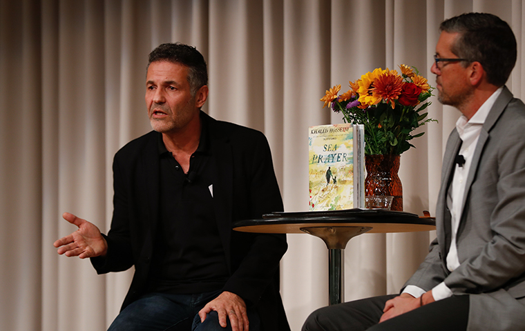 Khaled Hosseini and Steven Saum sit at a book reading of Sea Prayer image link to story