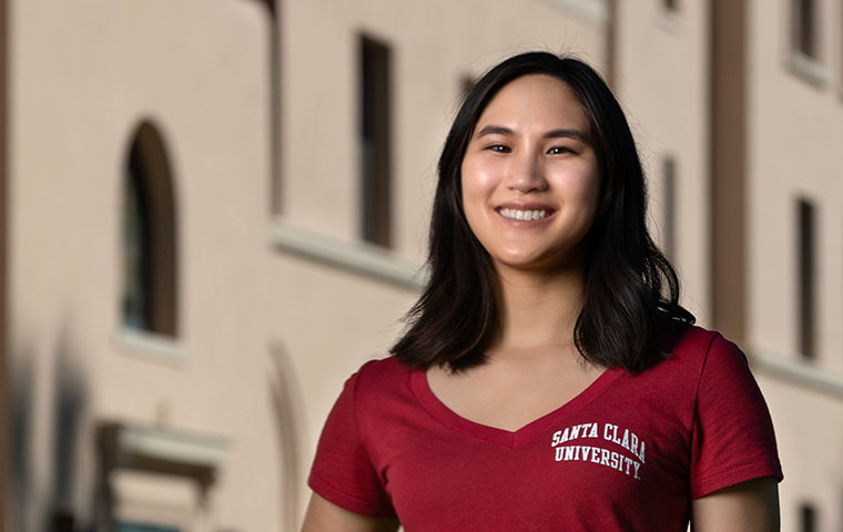 Kristi Nguyen standing in front of a building on campus image link to story