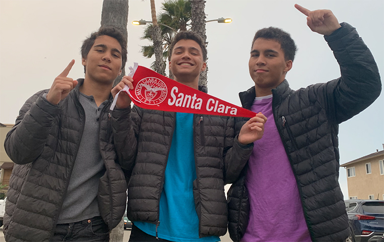 The Landoch triplets holding a Santa Clara pennant 